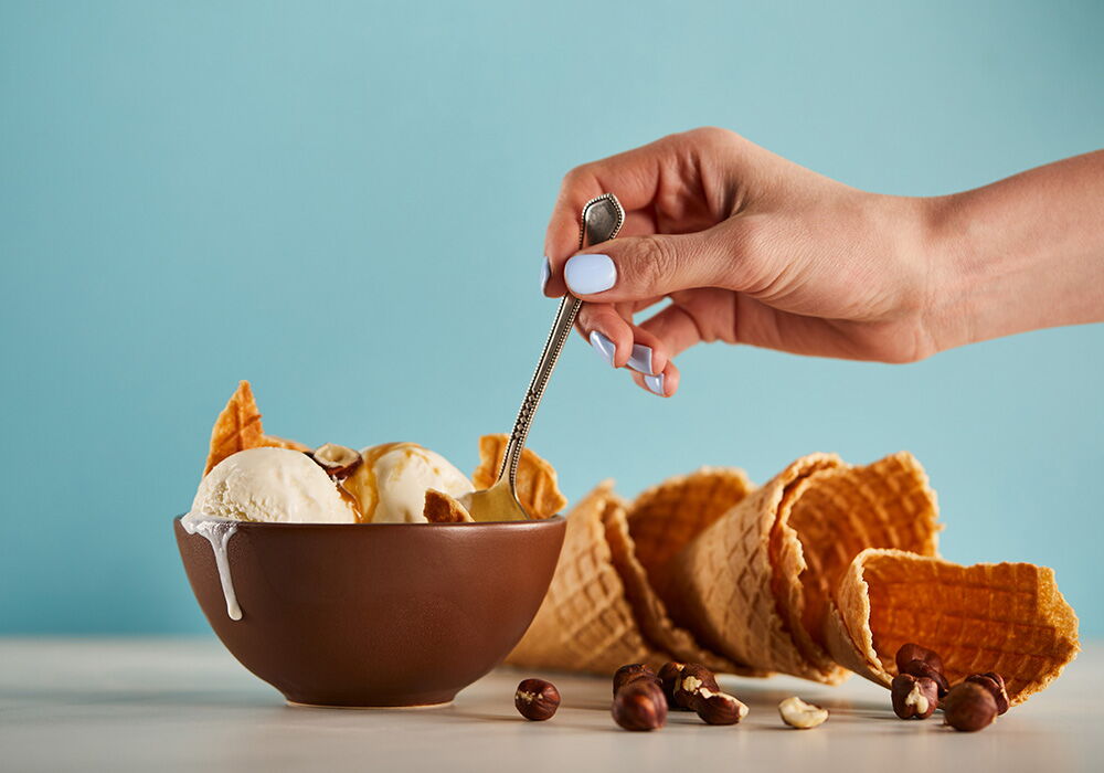 Il gelato viene mangiato da una donna con un cucchiaio da una coppa